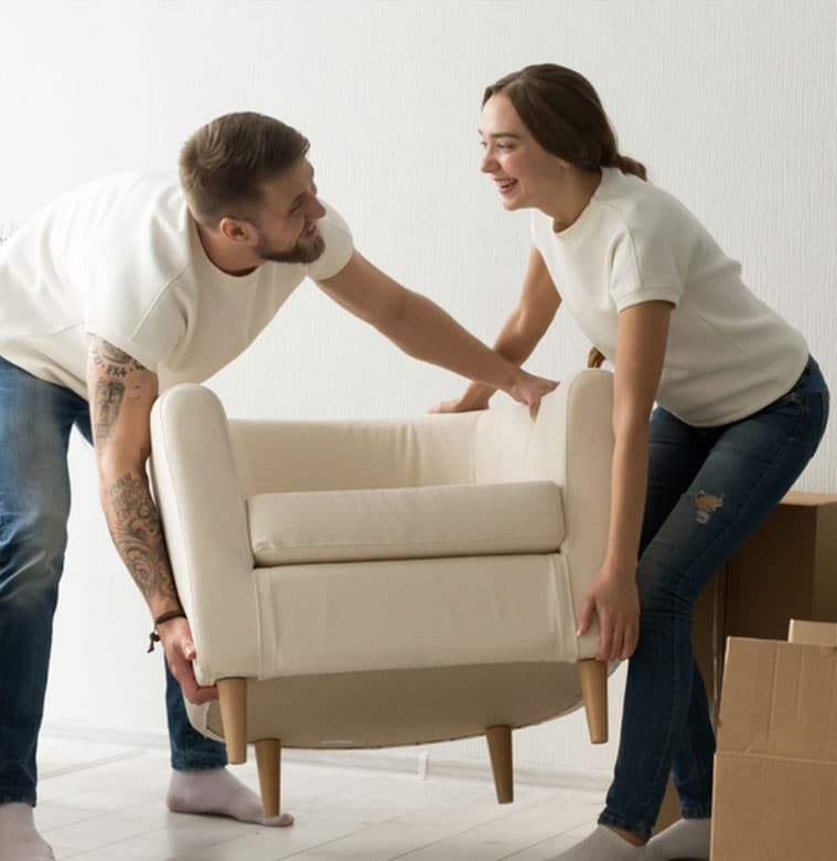 Young Couple Carrying Furniture Together - The Removals Group In Mermaid, QLD