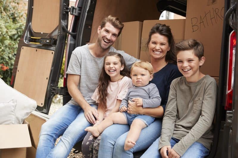 Family Sitting In Back Of Removal Truck — The Removals Group In Burleigh Heads, QLD